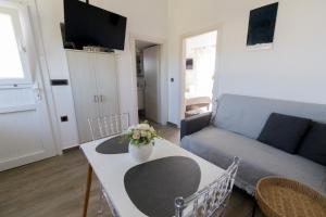 a living room with a couch and a table with flowers at La casa nel campo in Syros Island National Airport