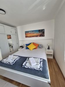 a white bedroom with a large bed in it at Apartment Perla in Dinjiška