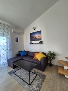 a living room with a couch and a table at Apartment Perla in Dinjiška