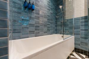 a blue tiled bathroom with a tub and a shower at The Crown & Greyhound by Innkeeper's Collection in London +63 photos
