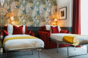 a hotel room with two beds and a couch at The Crown & Greyhound by Innkeeper's Collection in London