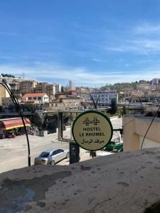 a sign for a hotel in a city at Hostel le Rhumel in Constantine +9 photos