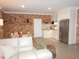 a living room with a white couch and a kitchen at The Honeypot in Balmoral