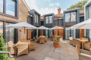a patio with tables and chairs and umbrellas at The Crown & Greyhound by Innkeeper's Collection in London