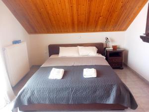 a bedroom with a bed with two towels on it at Family Booklovers space in Aigio