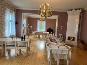 a dining room with white tables and a chandelier at Lantlivlodge i Österjörn -Herrgård in Österjörn
