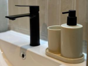 a bathroom sink with two soap dispensers on it at Covea by the Sea Boho Seaside Apartment, 400 m from the Beach in Perea +13 photos