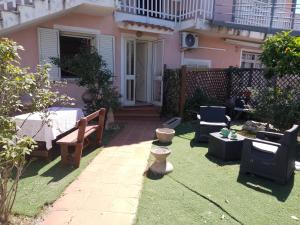 a yard with chairs and furniture in front of a house at Casa vacanze sa minda noa whit a private garden in Olbia