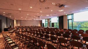 an empty room with chairs and a projection screen at Van der Valk hotel Veenendaal in Veenendaal