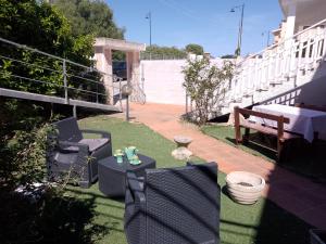 a patio with chairs and a table and a bench at Casa vacanze sa minda noa whit a private garden in Olbia +9 photos