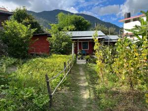 a path leading to a red house with a fence at Jumusing homestay in Rupa