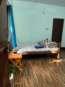 a small bed in a room with a table at Jumusing homestay in Rupa