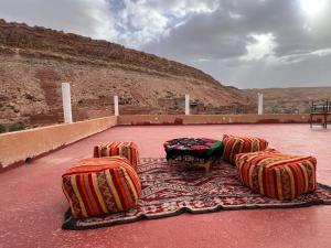 a group of chairs and a table on a carpet at Pergolas Tamakoucht in Ouarzazate