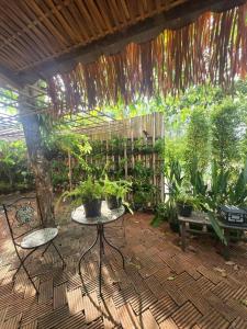 a patio with a table and a bunch of plants at Three Hen Lakeside in Ban Na Nai