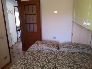 a small bedroom with a bed and a door at Casa vacanze sa minda noa whit a private garden in Olbia