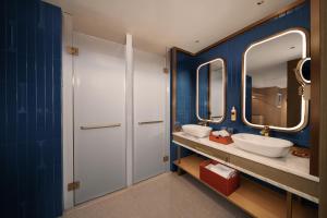 a bathroom with two sinks and two mirrors at 苏州云启一方酒店-凯悦尚选 in Suzhou +30 photos