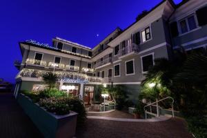 hotel w nocy z oświetleniem na fasadzie w obiekcie Hotel Savoia w Alassio