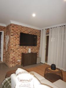 a living room with a couch and a brick wall at The Honeypot in Balmoral