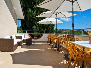 a patio with tables and chairs and white umbrellas at Villa Yucca - Luxury Glamping Experience in Torano Nuovo