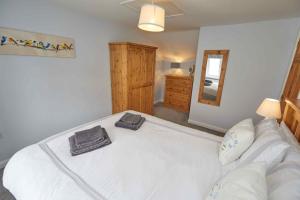 a bedroom with a large white bed and a mirror at Naam Place in Lincoln