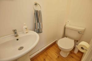 a bathroom with a white sink and a toilet at Naam Place in Lincoln