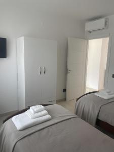 a white bedroom with two beds and white cabinets at TedHouse in Praia a Mare