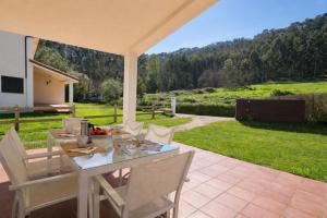 a table and chairs on a patio with a view at Casa en Llanes con jardín - Huergo Mar y Playa in Nueva de Llanes