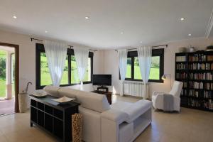 a living room with a white couch and a tv at Casa en Llanes con jardín - Huergo Mar y Playa in Nueva de Llanes