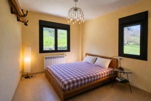 a bedroom with a bed and two windows at Casa en Llanes con jardín - Huergo Mar y Playa in Nueva de Llanes