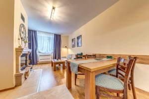 a living room with a wooden table and chairs at Ember Suite 1BR - Mountain Lake Complex By Flat Mаnager in Smolyan