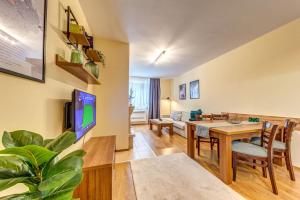a living room with a table and a dining room at Ember Suite 1BR - Mountain Lake Complex By Flat Mаnager in Smolyan
