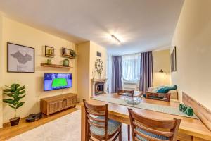 a living room with a tv and a couch and a table at Ember Suite 1BR - Mountain Lake Complex By Flat Mаnager in Smolyan