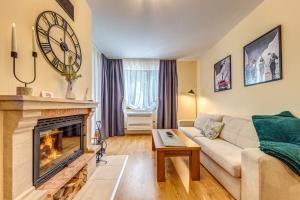 a living room with a couch and a fireplace at Ember Suite 1BR - Mountain Lake Complex By Flat Mаnager in Smolyan +14 photos