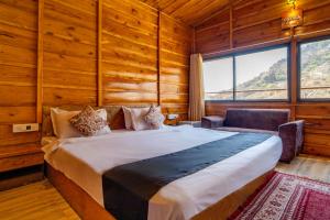 a bedroom with a bed in a room with wooden walls at BADIGARH RESORT - Udaipur in Thūr +116 photos