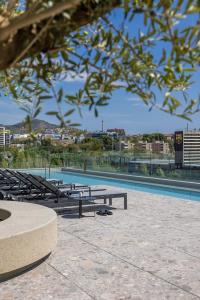 a group of benches sitting next to a swimming pool at Hotel SB Win 4 Sup in Sant Feliu de Llobregat