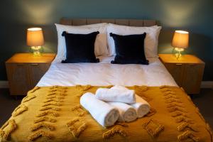 a bedroom with a bed with towels on it at The Butterleigh Inn in Cullompton