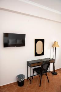 a desk with a mirror and a chair in a room at KAMVISSIS HOTEL in Tyros