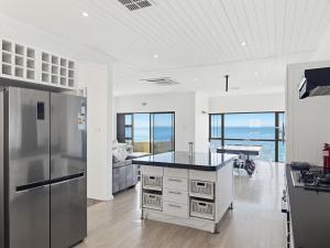 a kitchen with a refrigerator and a counter top at The Coastal Crown in Ballito