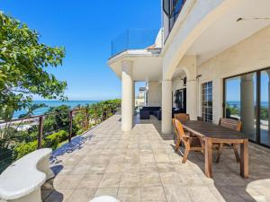 an outdoor patio with a wooden table and chairs at The Coastal Crown in Ballito