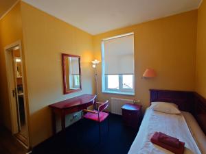 a bedroom with a bed and a desk and a window at Otrā Elpa in Valka