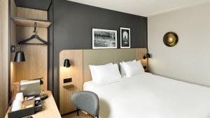 a hotel room with a bed and a desk with a computer at Campanile PRIME - Paris - Porte de Bagnolet in Bagnolet
