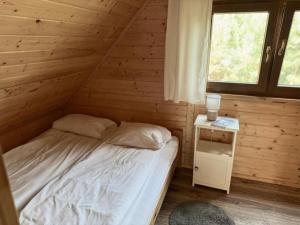 a bedroom with a bed and a small night stand at Domki w Lipnicy in Lipnica