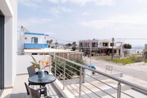 a balcony with a table and a view of a street at Ocean Breeze Residence in Kámpos