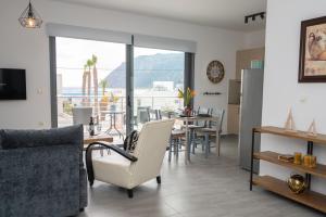 a living room with a table and chairs and a kitchen at Ocean Breeze Residence in Kámpos