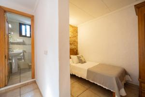 a bedroom with a bed and a bathroom with a sink at Hotel Lago Dorado in La Savina