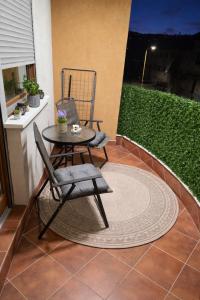 a patio with a table and chairs on a balcony at Apartman Anja'K in Doboj