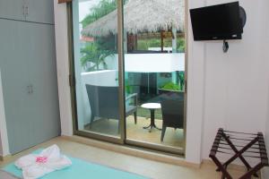 a room with a view of a balcony with a television at Villas Maria Isabel in Santa Cruz Huatulco