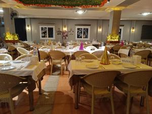 a dining room with tables and chairs with white tablecloths at Elflora Otel in Ceyhan