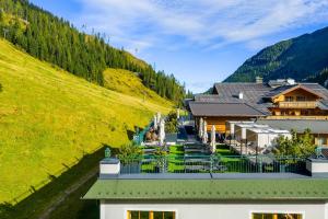 a view of a resort with a grassy hill at Hotel Alpenrose in Zauchensee
