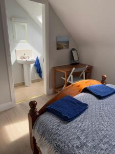 a bedroom with a bed and a bathroom with a sink at Sailing's Island Rooms in Inisheer